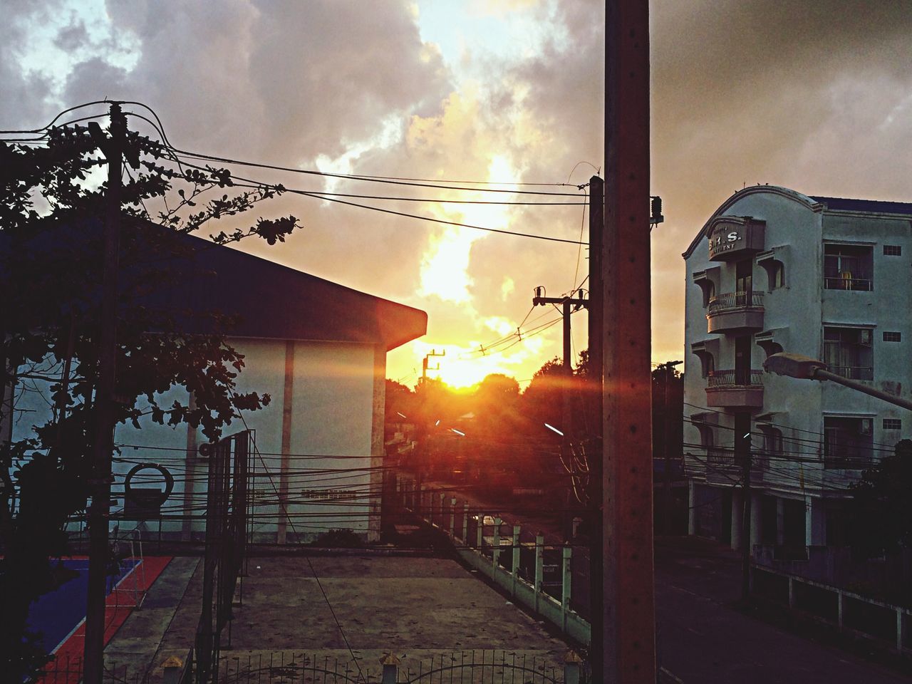 sky, built structure, architecture, building exterior, sunset, sun, cloud - sky, sunbeam, sunlight, house, cloudy, cloud, residential structure, lens flare, orange color, window, street light, outdoors, nature, no people