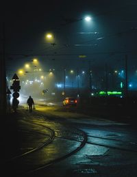 Man walking on illuminated street at night