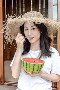 Portrait of young woman wearing hat standing at home