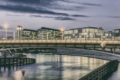 Bridge over river in city against sky