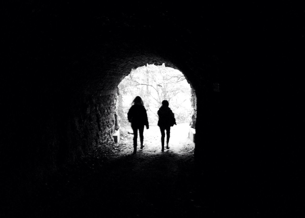 full length, silhouette, indoors, lifestyles, walking, men, tunnel, rear view, togetherness, standing, leisure activity, bonding, arch, love, person, dark, childhood