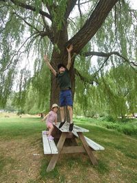 Siblings playing under willow tree