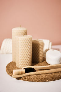 Bamboo toothbrushes and candles on pink background. reuse natural products