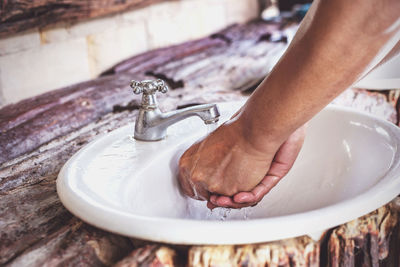 Person washing hands at faucet