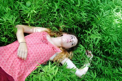 High angle view of woman lying on grassy field