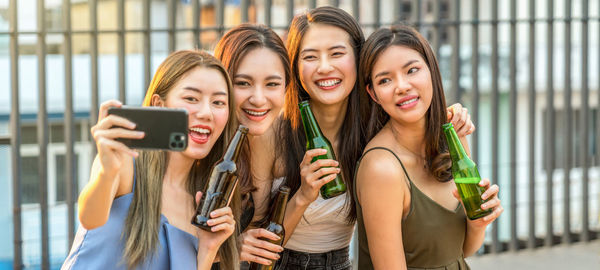 Happiness asian girl friend group taking a selfie while celebrating and dancing together 