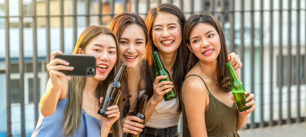 Portrait of smiling young woman using mobile phone