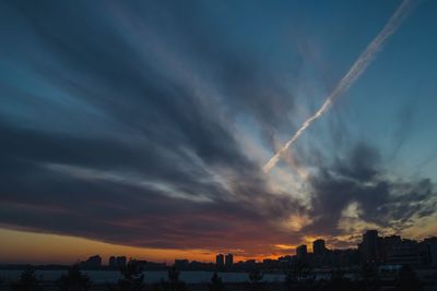 Scenic view of dramatic sky over city during sunset