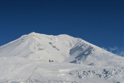 Scenic view of snowcapped mountains against clear blue sky