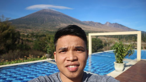 Portrait of young man against mountains