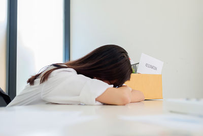 Woman leaning at desk in office