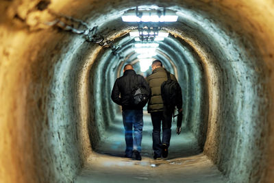 Rear view of man standing in tunnel