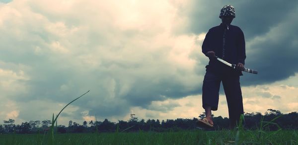 Man standing on field against sky