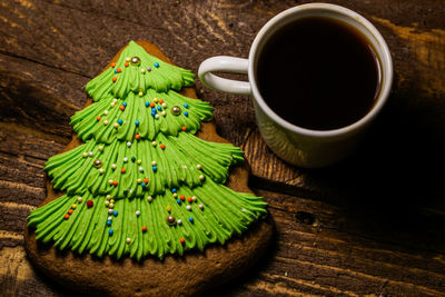 High angle view cookie and black tea on wooden table