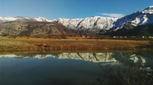 Scenic view of lake and snowcapped mountains against sky