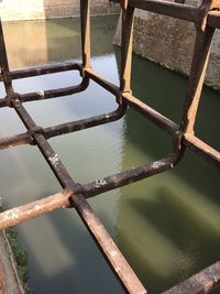 Close-up of metal fence by lake