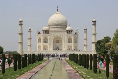 Tourists visiting taj mahal against clear sky