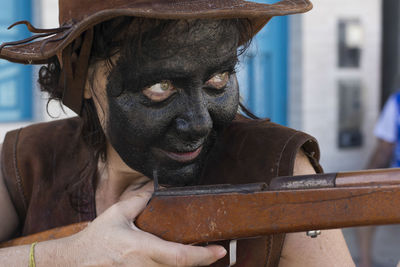 Caucasian woman with face made up in black color. 