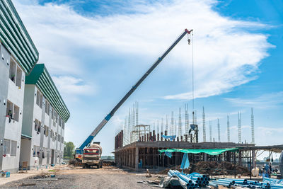 Concrete truck load concrete to bucket and mobile crain liftting pour on second floor in site.