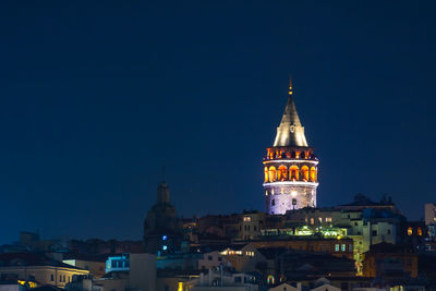 Illuminated buildings against sky at night