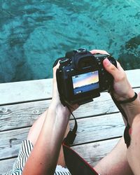 Midsection of woman holding camera