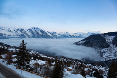 The swiss alps village of la tzoumaz, valais, switzerland, with fog covering the valley down below.