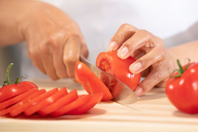 Cropped image of person preparing food on cutting board