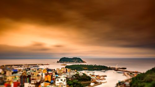 High angle view of townscape by sea against sky