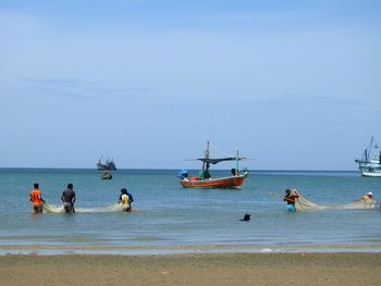 People on beach against sky