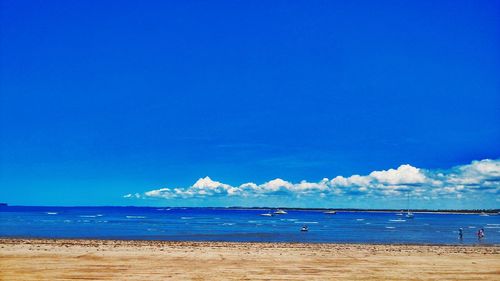 Scenic view of beach against blue sky