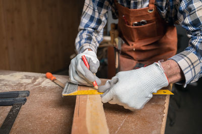 Midsection of carpenter working at workshop