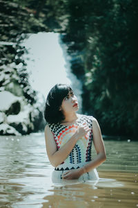 Young woman looking away in lake