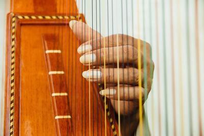 Close-up of hand playing harp