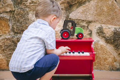 Side view of boy playing with toy sitting