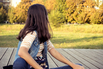 Rear view of woman sitting on bench