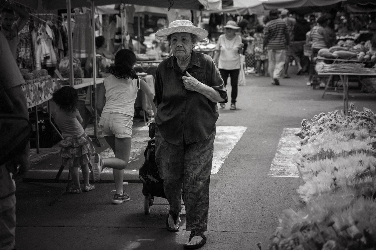 REAR VIEW OF PEOPLE WALKING ON STREET