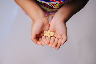 Cropped hand of woman holding gingerbread man cookies 