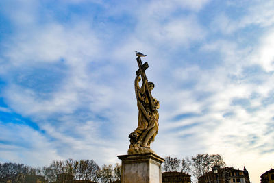 Low angle view of statue against cloudy sky