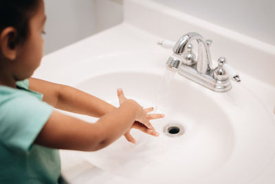 Cute girl washing hand at sink