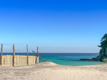 Scenic view of beach against clear blue sky