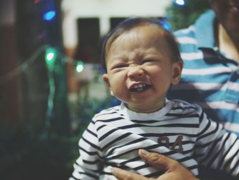 Midsection of man carrying smiling baby boy