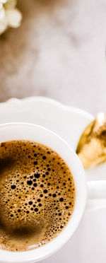 Cropped hand holding coffee cup on table