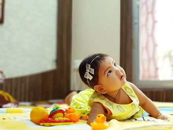 Cute baby girl lying down at home