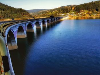 Arch bridge over river against sky