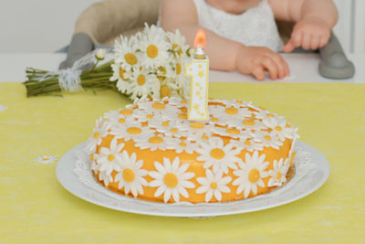 Yellow cake with daisy flowers for baby