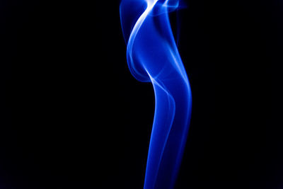 Close-up of blue smoke against black background