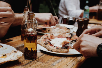 Cropped hands of people having food in restaurant