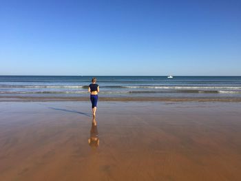 Man standing on beach against clear sky