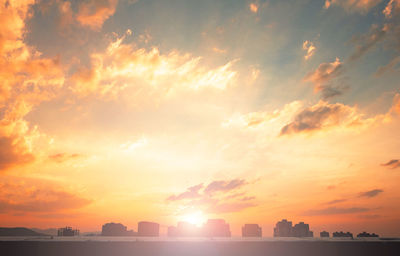 Silhouette city against sky during sunset