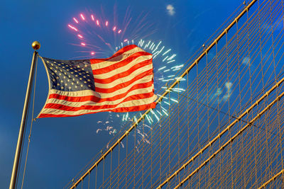 Low angle view of american flag against firework display